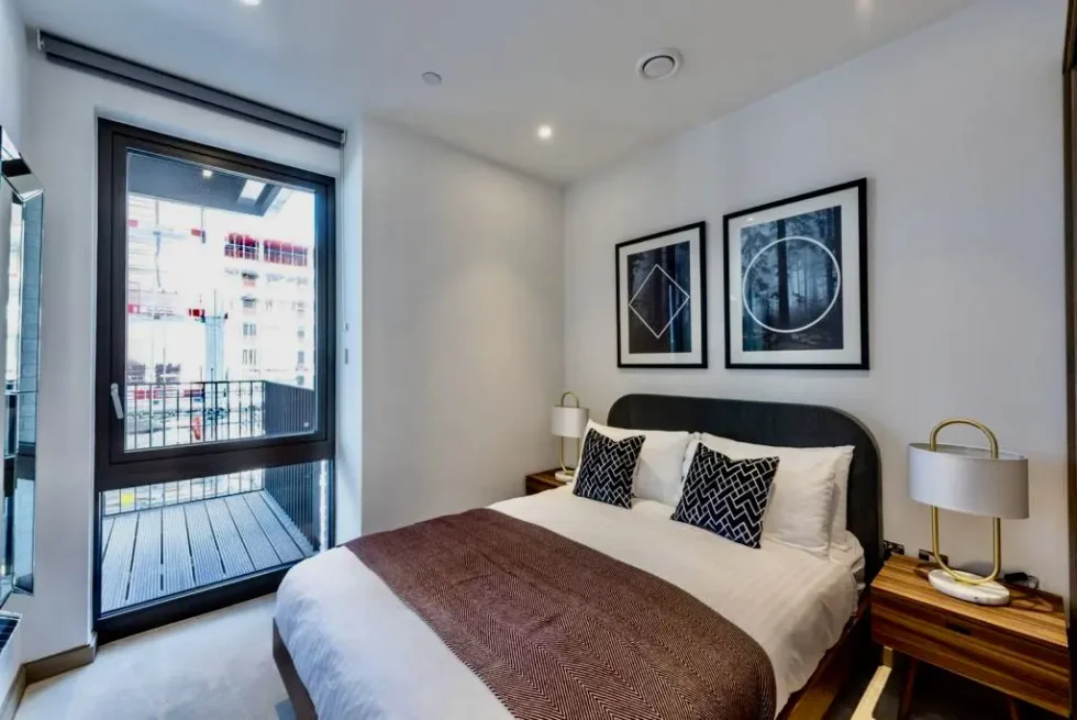 Second bedroom with a double bed and a glazed door onto the balcony