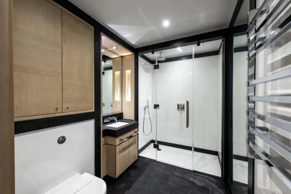 Second bathroom with a walk-in shower, wood cabinetry and heated towel rail