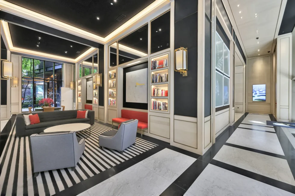 Seating area off the foyer, with bookshelves, sofas and a striped rug