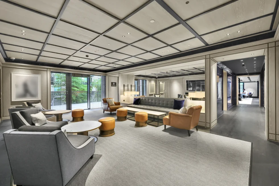 Residents' lounge with a coffered ceiling, soft seating and doors to a terrace