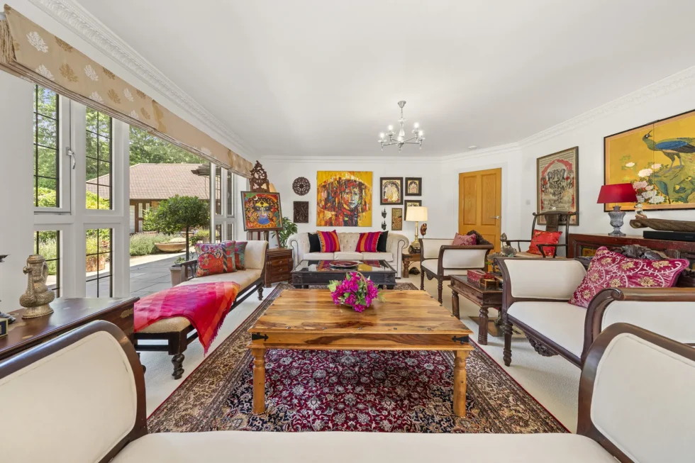 Living room with full-height windows and doors opening onto the paved terrace