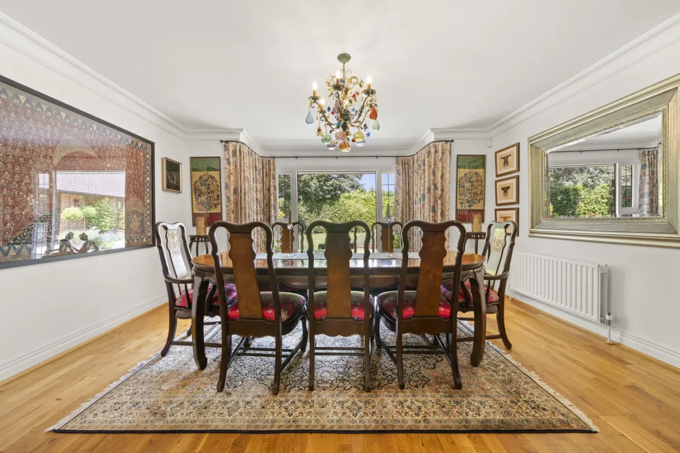 Formal dining room with oak floor, bay window over the garden and seating for eight
