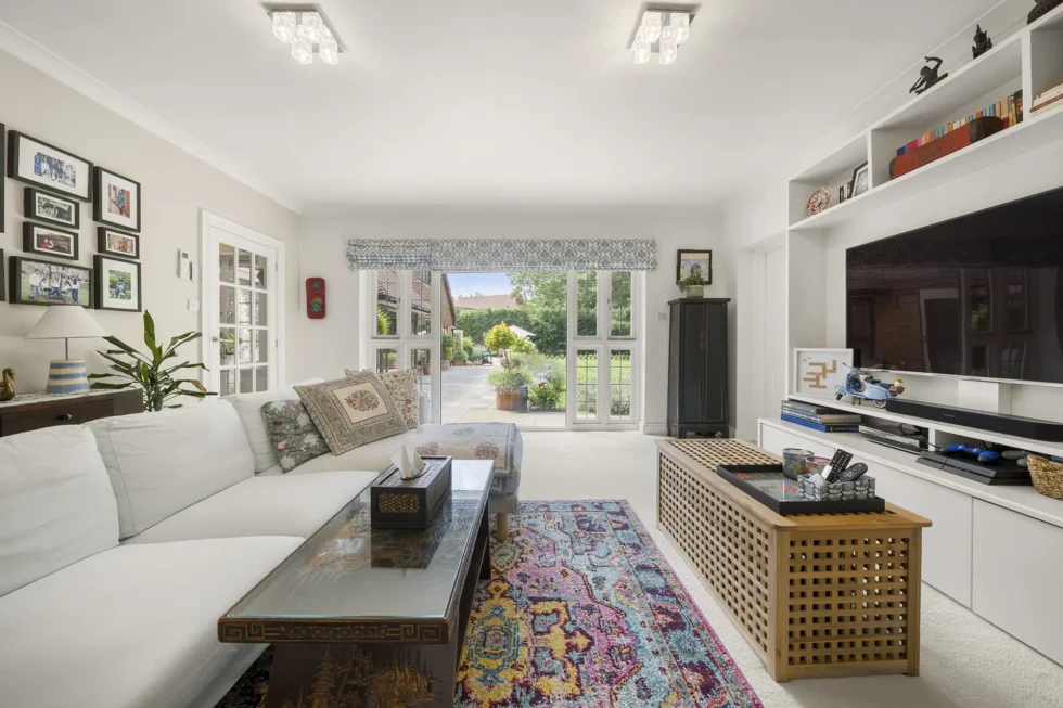 Family room with corner sofa and French doors opening onto the rear terrace