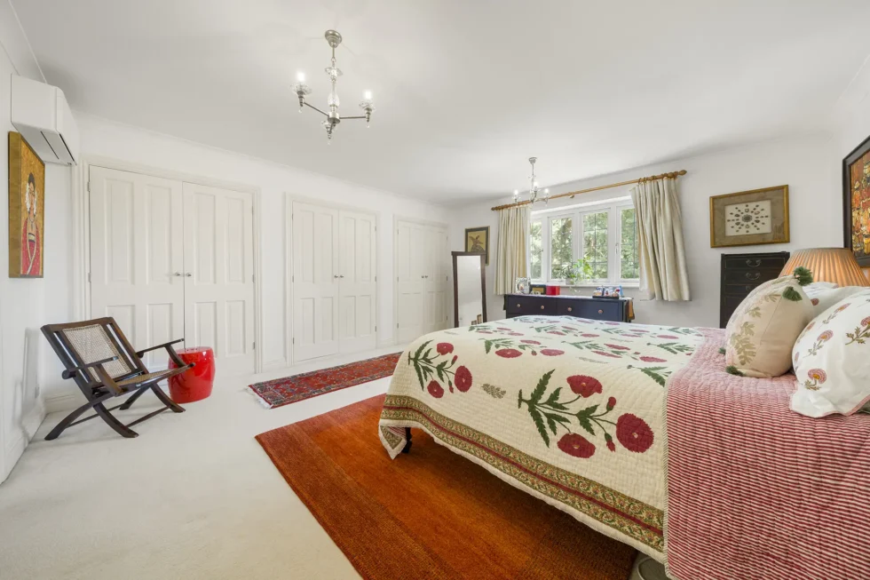 Principal bedroom showing three banks of fitted wardrobes and air conditioning