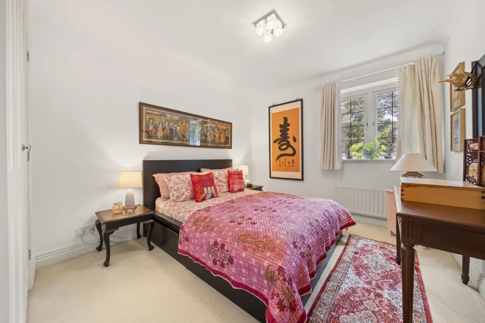 Double bedroom with writing desk and window overlooking mature trees